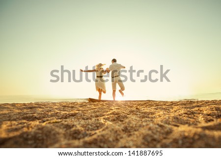 couple sitting on the beach at sunrise