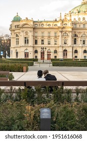 A Couple Sitting On Bench In Empty Public Square