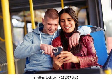 Couple Sitting On A Bus Seat, Looking At A Phone, Hugging And Having Good Times Browsing The Internet While Commuting