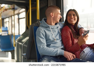 Couple Sitting On A Bus Seat, Looking At A Phone, Hugging And Having Good Times Browsing The Internet While Commuting