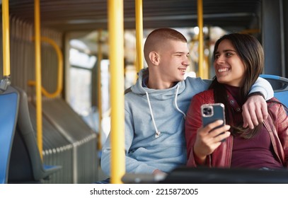 Couple Sitting On A Bus Seat, Looking At A Phone, Hugging And Having Good Times Browsing The Internet While Commuting