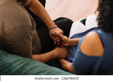 Couple Sitting On Couch Praying Together