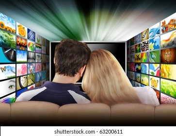 A Couple Is Sitting On A Couch Watching A Flat Screen Television With Photo Images. The Tv Has A Glowing Light Coming Out The Top. Use It For A Media, Entertainment, Technology Or Date Night Concept.