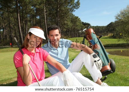 Couple sitting on a golfcourse