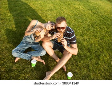 couple sitting on the grass in the park and eating sandwiches smiling
 - Powered by Shutterstock