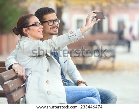 Similar – couple taking selfie in the street