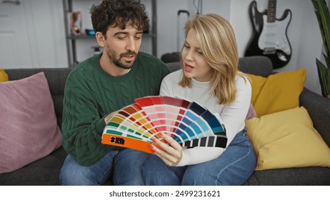 A couple sitting on a sofa indoors, looking at a color swatch, discussing home decoration options together. - Powered by Shutterstock