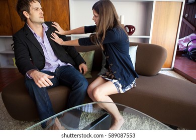 Couple Sitting On Sofa, Woman Pushing Man Away