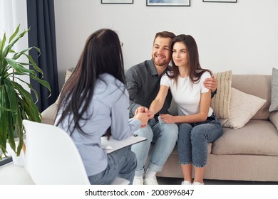 Couple is sitting on the sofa and working with female psychologist. - Shutterstock ID 2008996847