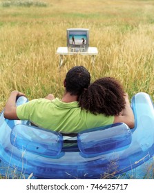 Couple Sitting Outside Watching TV