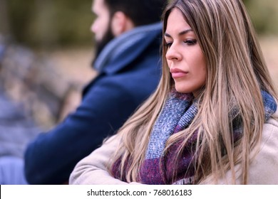 Couple Sitting In Park Having Relationship Problems