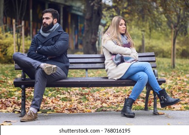 Couple Sitting In Park Having Relationship Problems