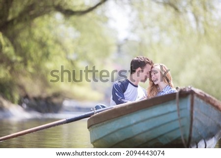 Couple sitting in rowboat on river