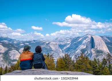 A couple sitting in Sentinel Dome looking at Yosemite National Park. United States - Powered by Shutterstock