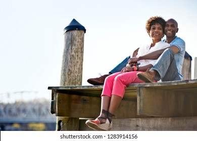 Couple Sitting Together On Wharf.
