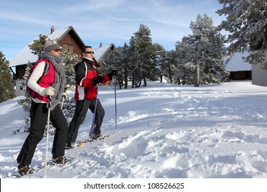 Couple Skiing By Chalets