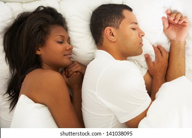 Couple Sleeping In Bed Together