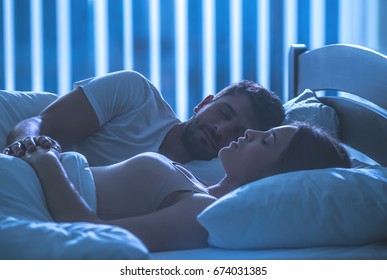 The couple sleeping and hold hands in a bed. night time, full grip focus