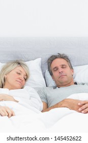 Couple Sleeping Soundly In Their Bed At Home In Bedroom