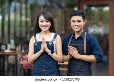 Couple Small Business Owners Smiling And Welcoming While Standing At Entrance Door. Closeup Asian Partner Small Business Owner At Entrance Of Newly Opened Restaurant With Open Sign Board