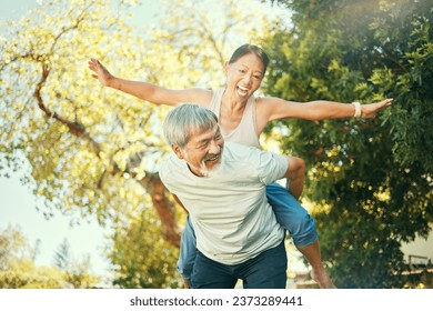 Couple, smile and piggyback in nature for fun, excited and playful in freedom, energy and joy. Happy elderly asian people, airplane and flying in summer, laugh and support for crazy in retirement - Powered by Shutterstock