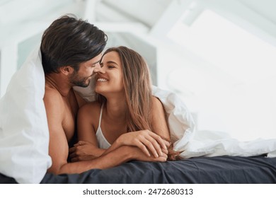 Couple, smile and under blanket in bed for morning romance, love and bonding on weekend. Relationship, man and woman laying together in home for comfort, relax or care and playing with partner - Powered by Shutterstock