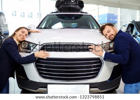 Couple smiling embracing car auto in auto salon