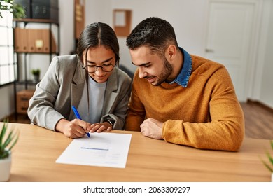 Couple smiling happy reading document at the office. - Shutterstock ID 2063309297