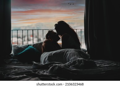 The couple is smiling and hugging while spending time together in bed. Selective focus 