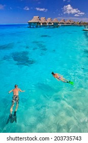 Couple Snorkeling In The Blue Lagoon, Bora Bora, French Polynesia, South Pacific