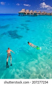 Couple Snorkeling In The Blue Lagoon, Bora Bora, French Polynesia, South Pacific 