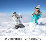 Couple in snowy mountain doing snowballs fight