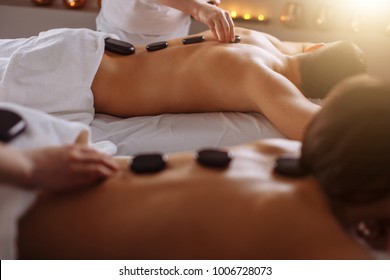 couple in spa salon having hot stone massage