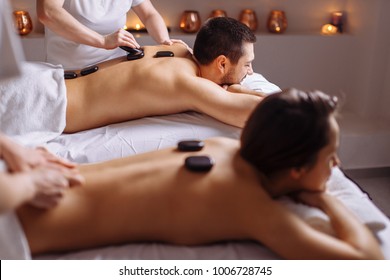 Couple In Spa Salon Having Hot Stone Massage