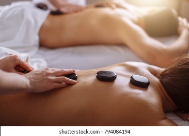 Couple In Spa Salon Having Hot Stone Massage