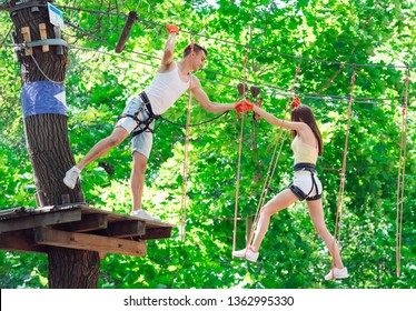 couple spend their leisure time in a ropes course. man and woman engaged in rock-climbing - Powered by Shutterstock