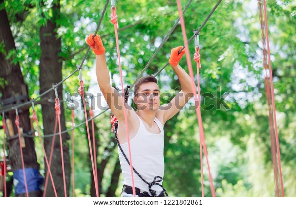 couple spend their leisure time in a\
ropes course. man and woman engaged in\
rock-climbing
