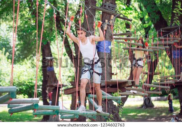 couple spend their leisure time in a
ropes course. man and woman engaged in
rock-climbing