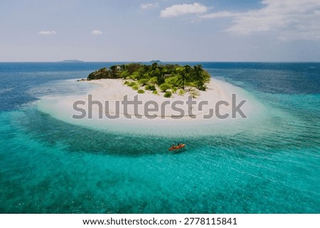 Couple spending time on a beutiful remote tropical island in the philippines. Concept about vacation and lifestyle.  kayaking and doing activities