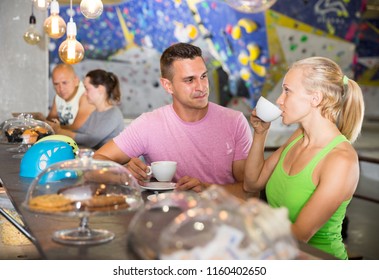 Couple of sporty people relaxing during workout at bouldering gym, drinking coffee in cafeteria

 - Powered by Shutterstock