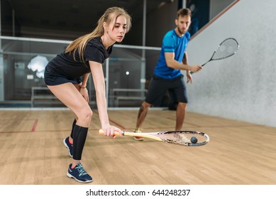 Couple with squash rackets, indoor training club