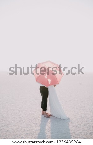 Couple stand behind a umbrealla in Sult Lake in Turkey