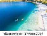 Couple stand up paddle boarding  on Lake Mckenzie, Fraser Island, Queensland, Australia