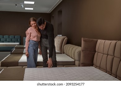 Couple standing among beds in furniture store - Shutterstock ID 2093254177