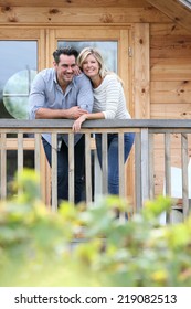 Couple Standing In Log Cabin Terrace 