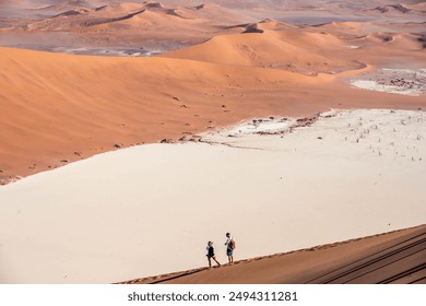 couple standing on big daddy sand dune, having a view over deadvlei, sossusvlei, namibia - Powered by Shutterstock