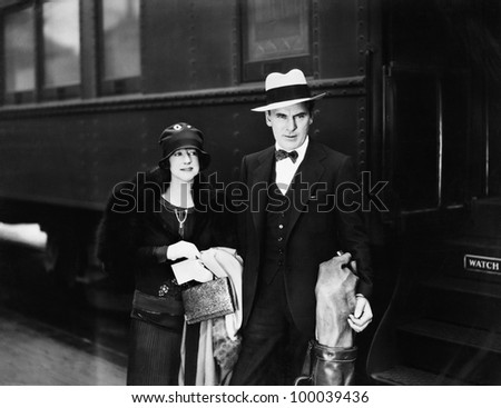 Couple standing at a railroad station platform
