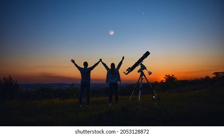 Couple Stargazing Together With A Astronomical Telescope.