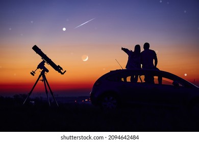 Couple stargazing together with a astronomical telescope. - Powered by Shutterstock