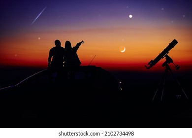 Couple Stargazing Together With A Astronomical Telescope.